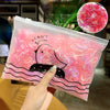 A clear plastic bag filled with pink and white elastic hair bands featuring a black duck design.
