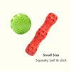 Una pequeña pelota chirriante verde y un juguete de palo naranja y rojo para perros.