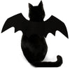 Un chat noir portant un costume à thème chauve-souris avec de grandes ailes noires.