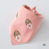 A pink cotton pet bandana with a green leaf and white flower pattern.
