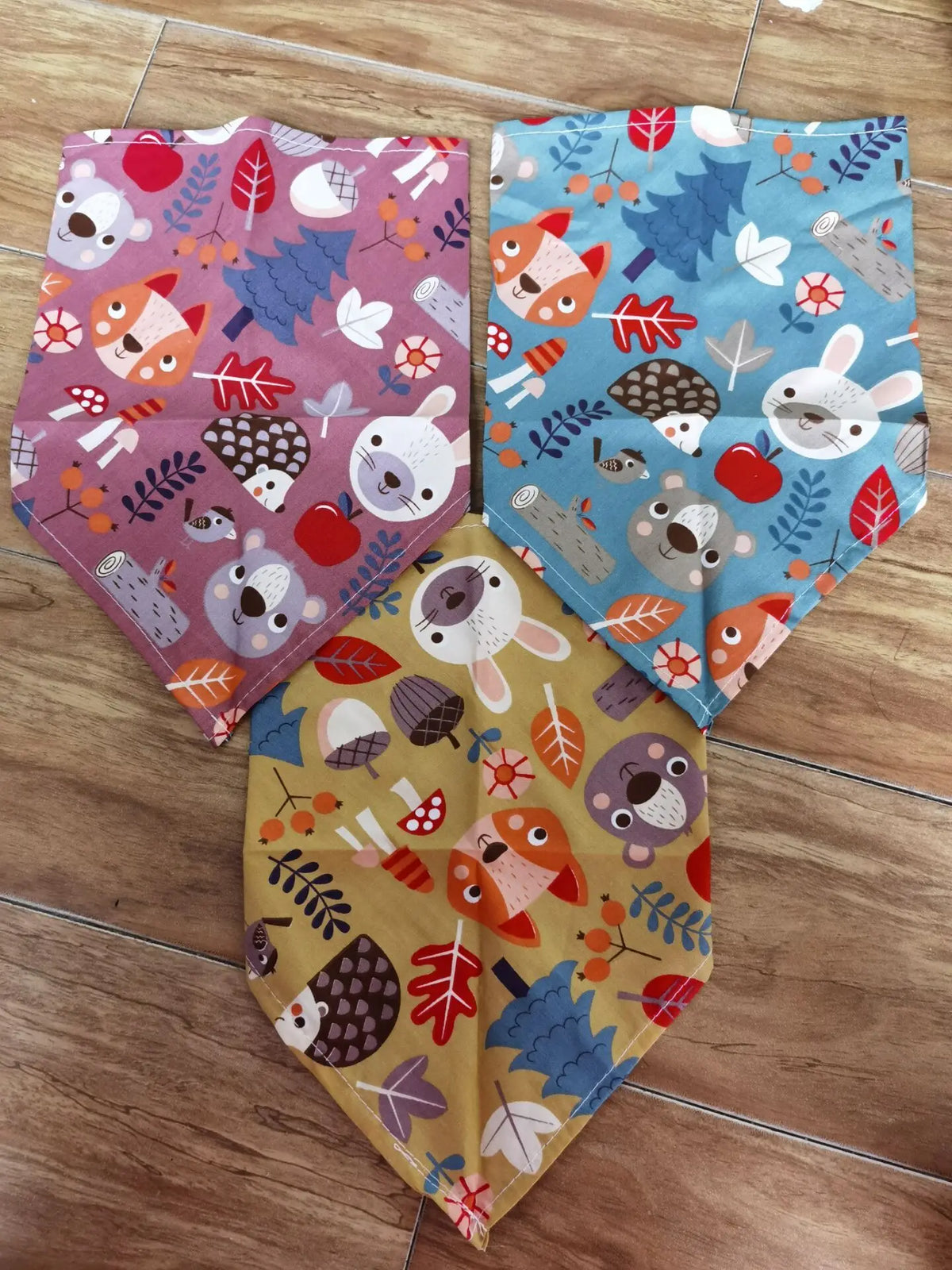 Three colorful cotton pet bandanas featuring woodland animal patterns for dogs and cats