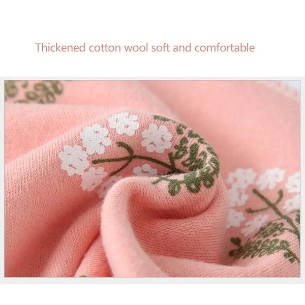 Close-up of a soft pink cotton wool fabric with green floral embroidery.