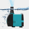 A teal and black submersible water pump is shown with water splashing above it.