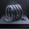 A coiled black aquarium air tube aerator with small water droplets spraying around it.