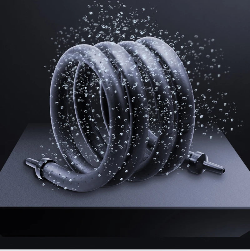 A coiled black aquarium air tube aerator with small water droplets spraying around it.