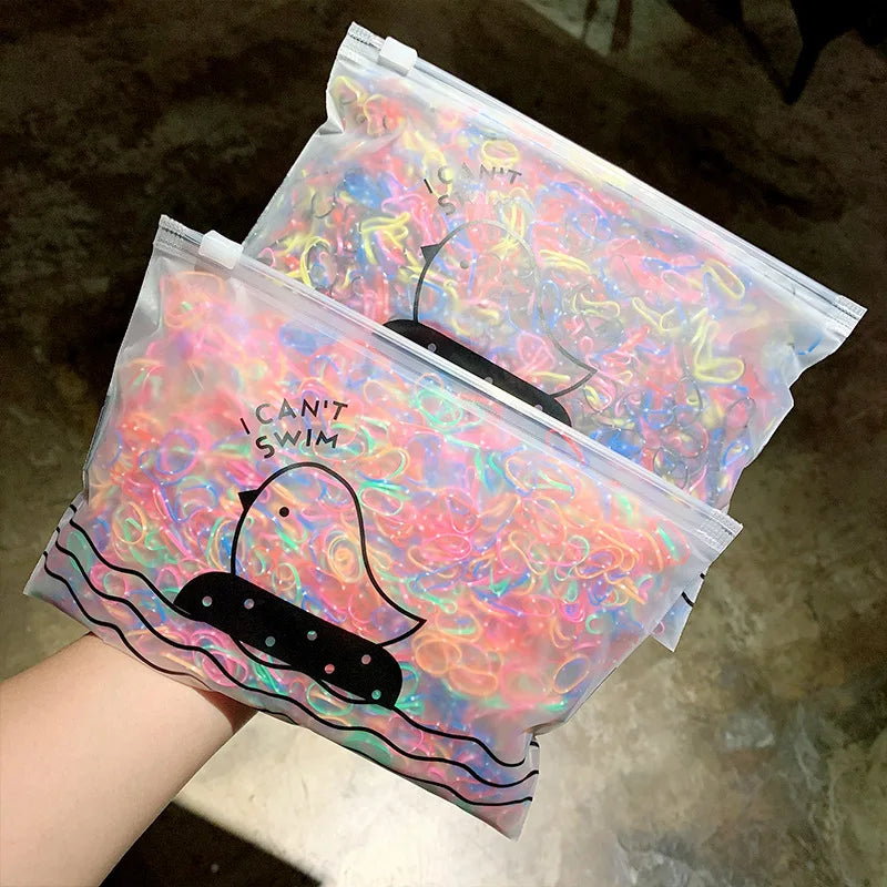A clear plastic package of colorful disposable elastic hair bands for girls is shown.