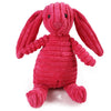 Un juguete de conejo de peluche rosa brillante y texturizado con orejas largas.