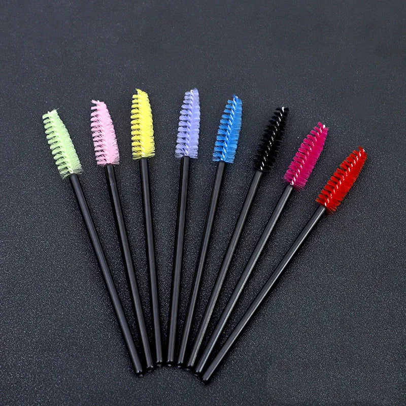 A collection of ten disposable eyelash brushes in various colors including green, pink, yellow, blue, and red