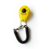 Yellow pet training clicker with a black eye and a metal wrist strap attached.