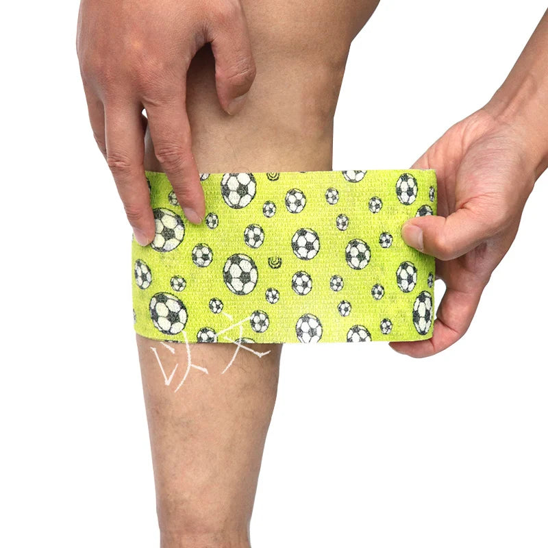 A hand is applying a yellow patterned self-adhesive elastic bandage tape to a person's leg.