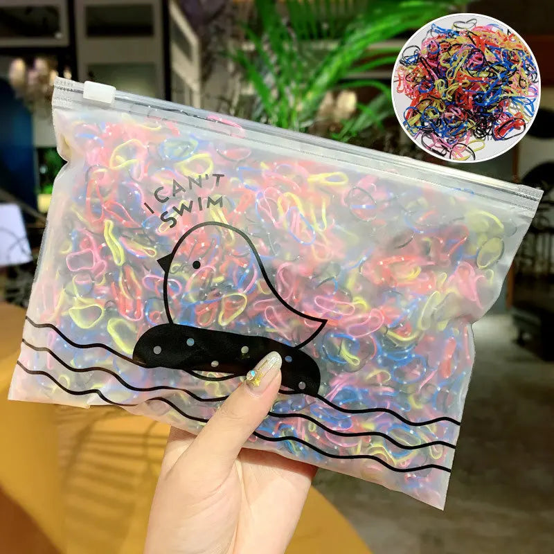 A clear plastic bag filled with colorful disposable elastic hair bands and a black silhouette of a duck.