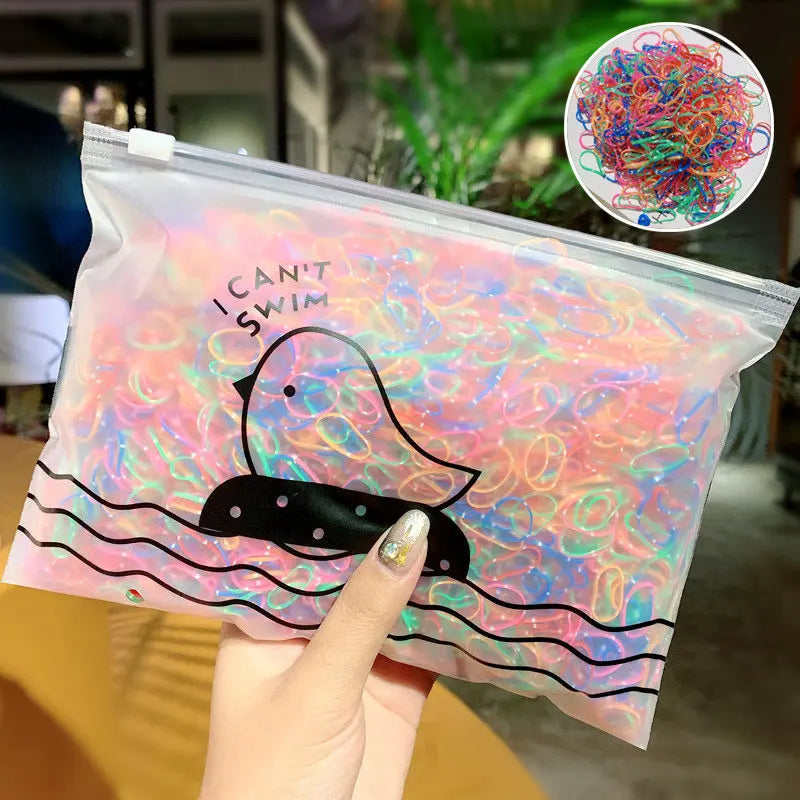 A hand holds a clear plastic bag filled with colorful elastic hair bands and a circular display of the product.
