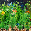 A vibrant green artificial water grass plant with several small fish swimming among the leaves.