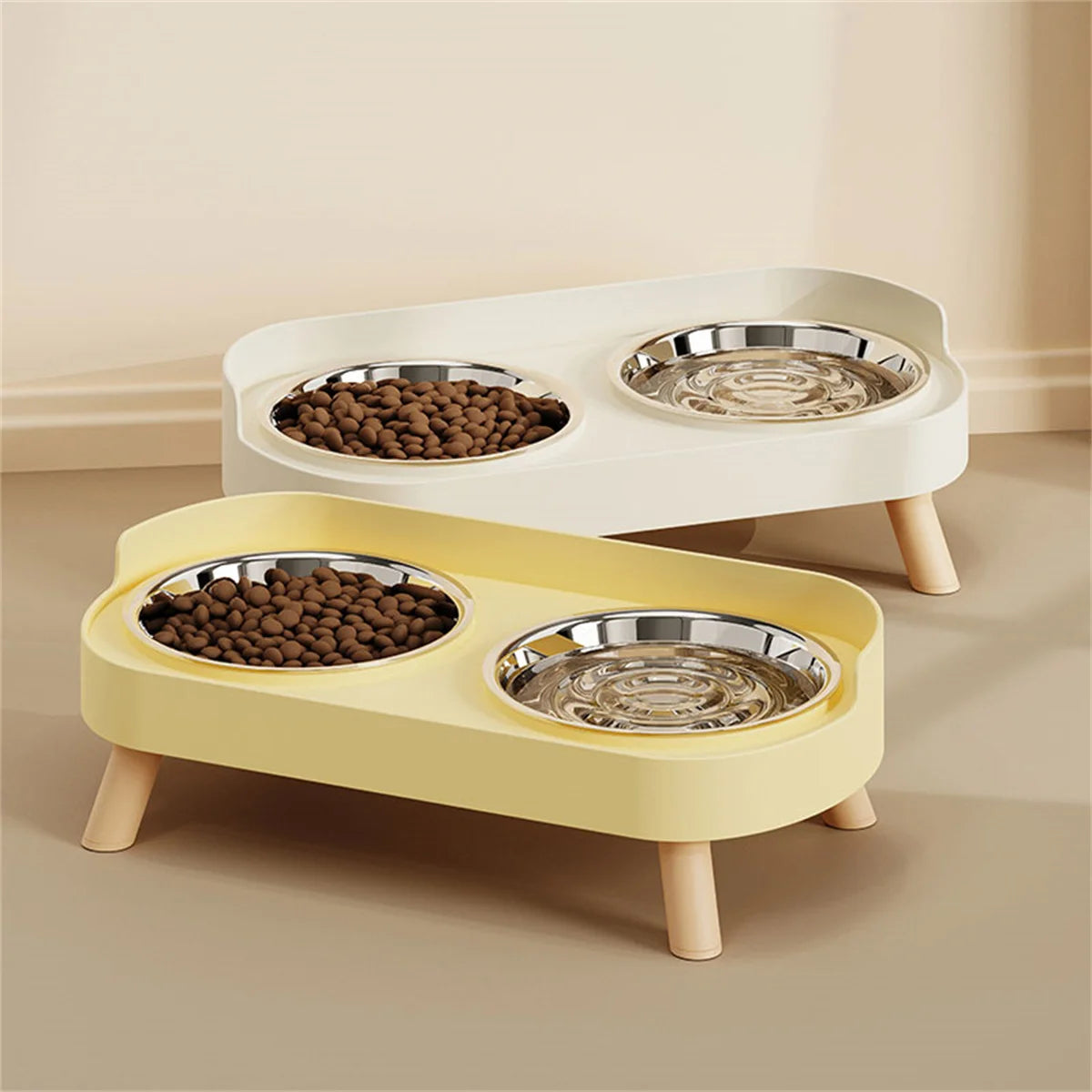 Two light-colored pet feeding dishes, one yellow and one white, for dogs and cats.
