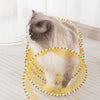 A fluffy gray and white cat is playing inside a yellow mesh foldable cat hunting tunnel on a light-colored floor.