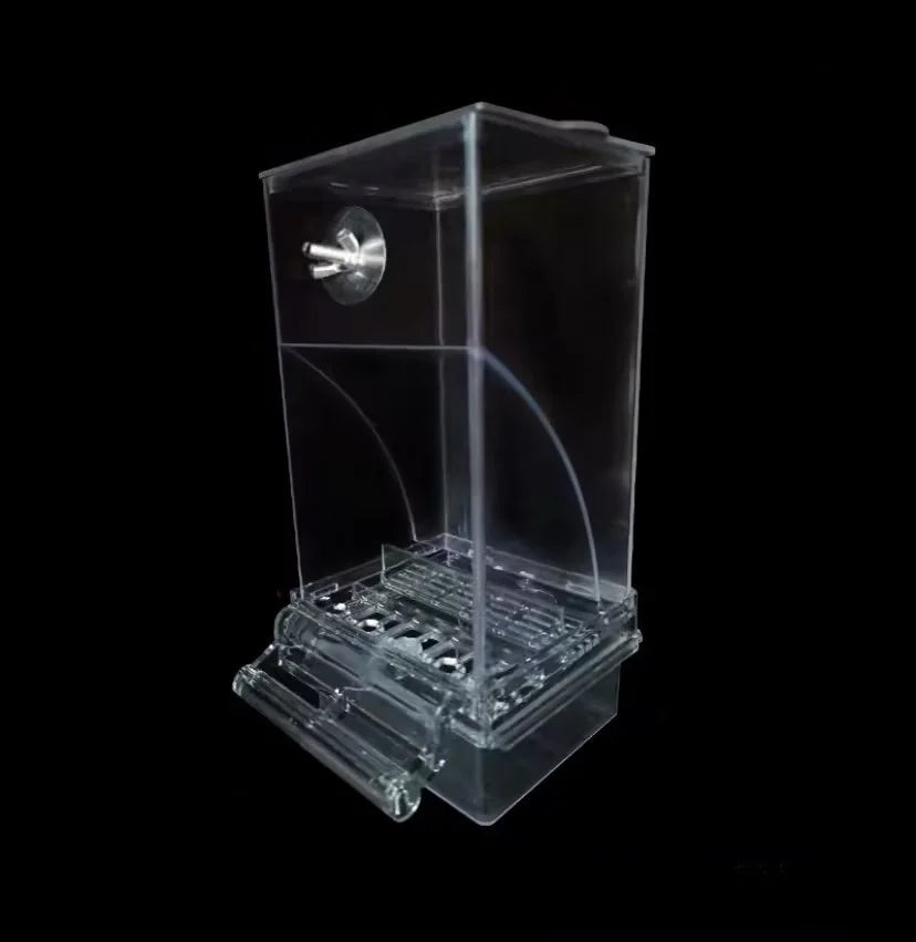 Distributeur automatique de nourriture pour oiseaux en plastique transparent avec chambre et mécanisme d'alimentation.
