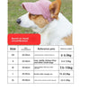 A white and brown dog wearing a pink baseball cap, shown in profile.
