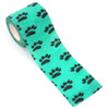 A roll of bright teal fabric featuring a pattern of black paw prints for pet leggings.