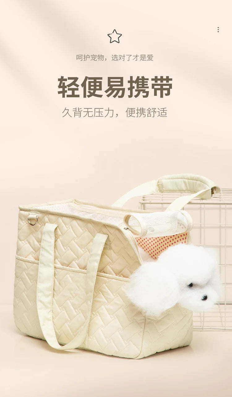 A light beige quilted portable pet carrier bag with light beige straps and a white fluffy toy is displayed on a neutral backg