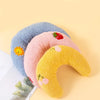 Un set de trois coussins pour animaux doux et duveteux bleu, rose et jaune sur un fond clair.