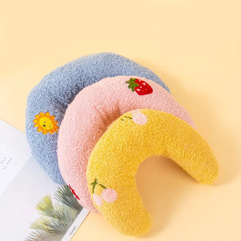 Un set de trois coussins pour animaux doux et duveteux bleu, rose et jaune sur un fond clair.