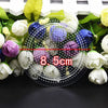 A clear petri dish filled with colorful Hama beads and tweezers, surrounded by fresh flowers.