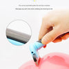 A hand uses a round-head grooming tool to comb pet hair from a pink object.