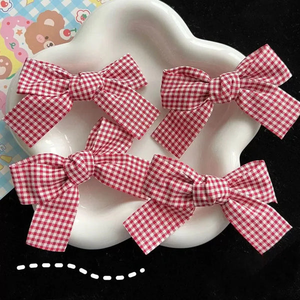 Several red and white plaid fabric bows are displayed on a white plate.