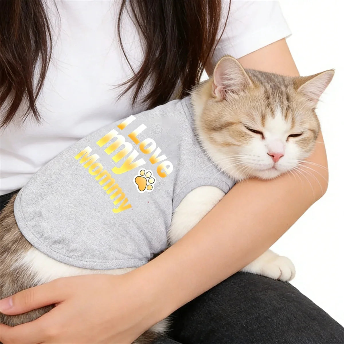 A female holds a gray pet sweater with yellow text on it, featuring a cat's paw print design.