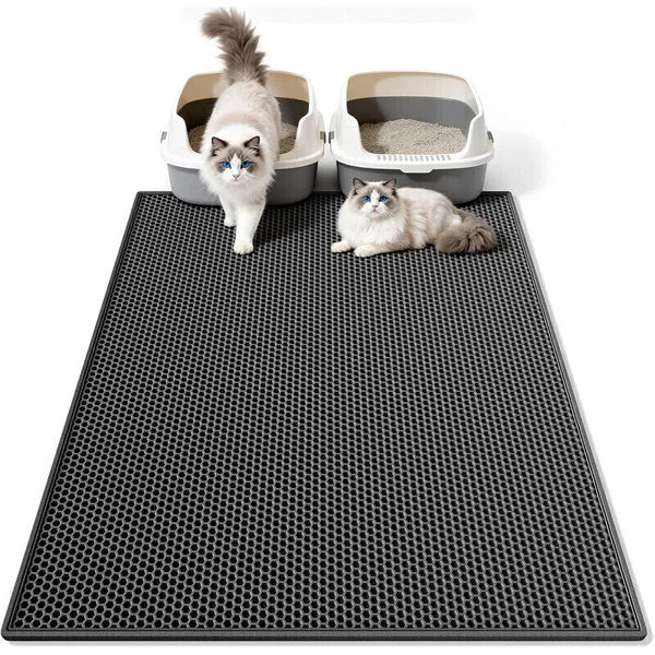 A fluffy cat sits on a black honeycomb double-layer litter mat with two litter boxes visible in the background.