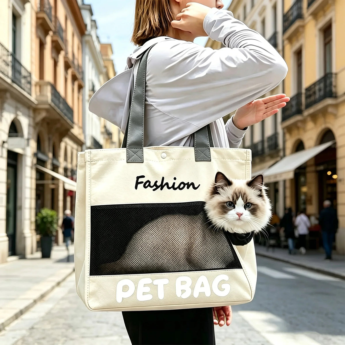 A person is carrying a beige pet bag with a black cat silhouette design on the front while walking outdoors.