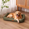 A golden retriever lies comfortably on a green orthopedic dog bed indoors.