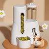 Un distributeur automatique de nourriture et d'eau pour hamsters blanc, posé sur une surface en bois à côté d'un petit hamste