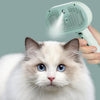 Un gato blanco y azul peludo mira a la cámara mientras una mano sostiene un peine de pelo verde y un cepillo de vapor sobre é