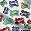 A collection of silicone dog bone molds in various colors and glitter textures for resin casting.