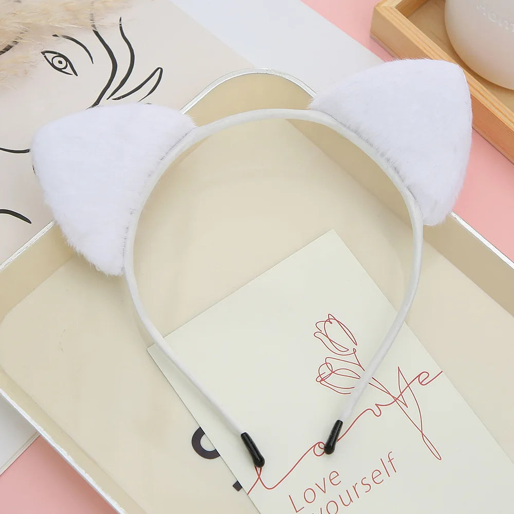 A white plush cat ear headband is displayed inside a light-colored box with a handwritten message.