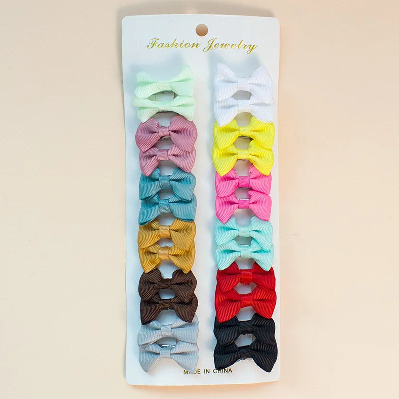 A collection of colorful pet hair clips for dogs and cats in various shades of pink, yellow, blue, green, and black.