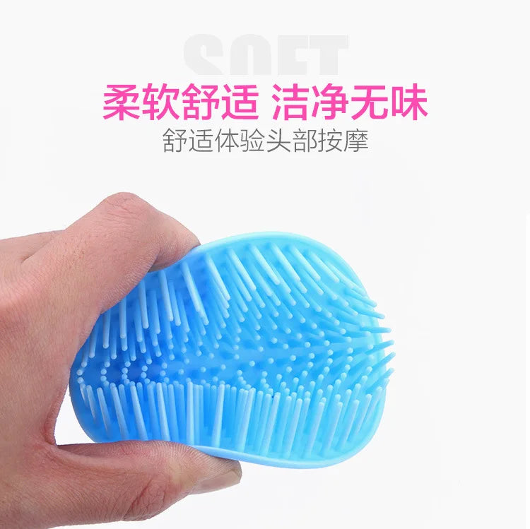 A hand holds a bright blue silicone brush with numerous bristles, used for scalp massage.