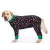 A golden retriever wearing a black and pink cartoon animal print jumpsuit.