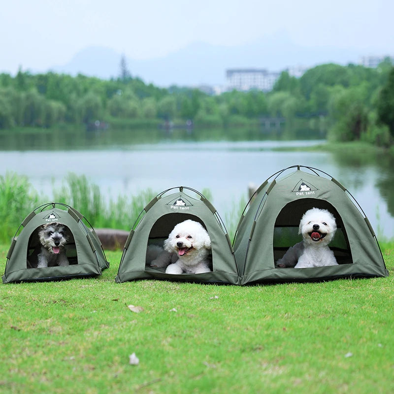 Drei olivgrüne, faltbare portable Tierhäuschen für Katzen und Hunde auf grünem Gras am See.