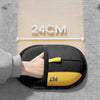 A hand holds a black double-sided pet grooming glove with a yellow PET tip, placed on a beige measuring guide.
