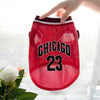 A red dog sports jersey with black lettering and the number 23 is being held by a hand.