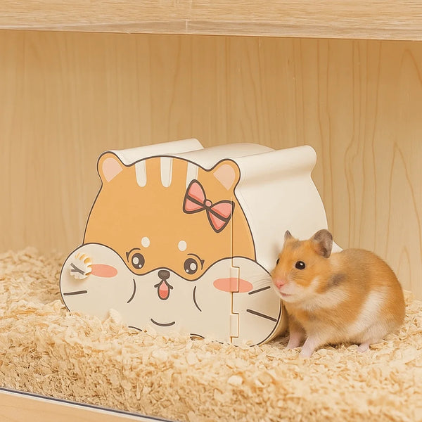A cute cartoon hamster hideout house shaped like a tiger face with an opening, resting on light brown bedding.