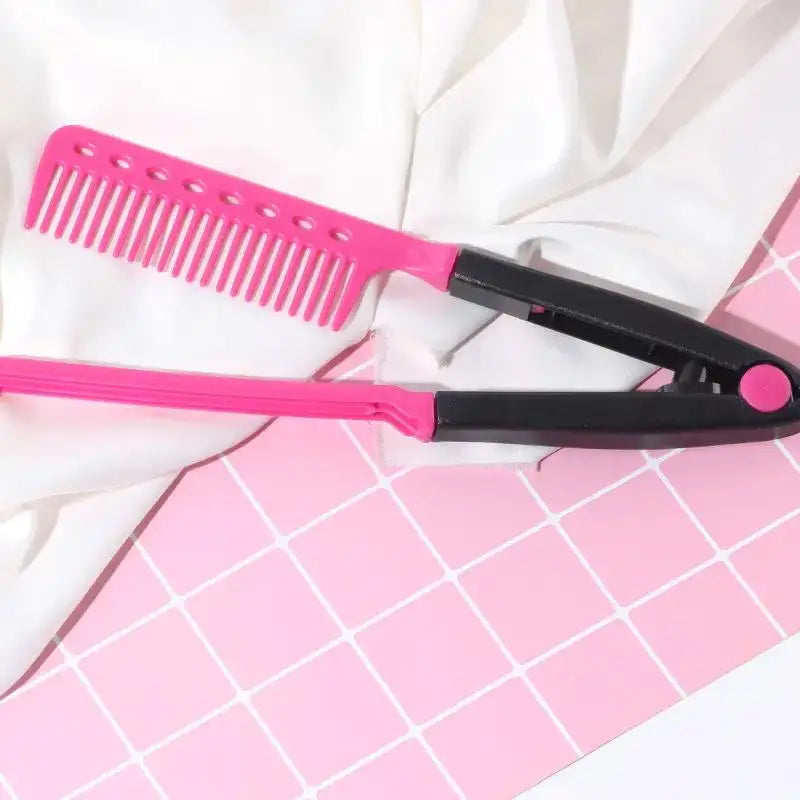 Peigne lisseur en forme de V rose et noir sur une surface à grille rose avec du tissu blanc.