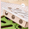 A cat puzzle toy featuring artistic felt pieces and a green base for indoor playtime.