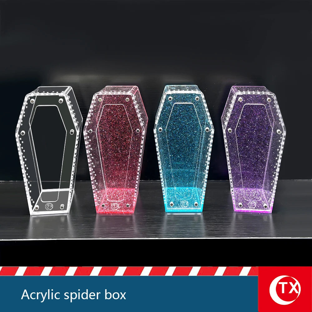 A row of four clear acrylic spider boxes with glitter finishes displayed on a dark surface.