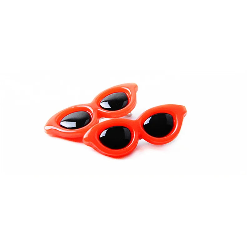 A pair of bright orange pet hair clips for dogs and cats with black accents.