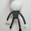 A white cartoon skeleton dog plush toy with black stripes and limbs hanging against a light background.