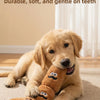 A golden retriever puppy is lying down, playing with a brown squeaky dog chew toy.