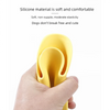 A hand is holding a yellow silicone dog muzzle designed for small to medium dogs.